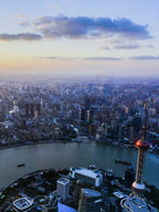 Huangpu River sunset view in Shanghai with cargo ships and Lujiazui skyline silhouette