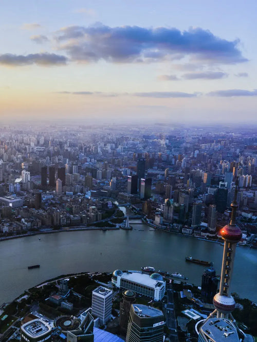 Huangpu River sunset view in Shanghai with cargo ships and Lujiazui skyline silhouette